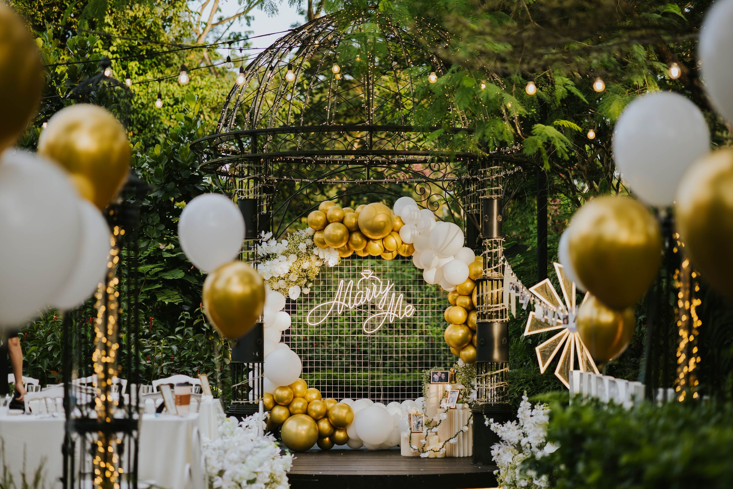 Gold and white balloon setup in a garden