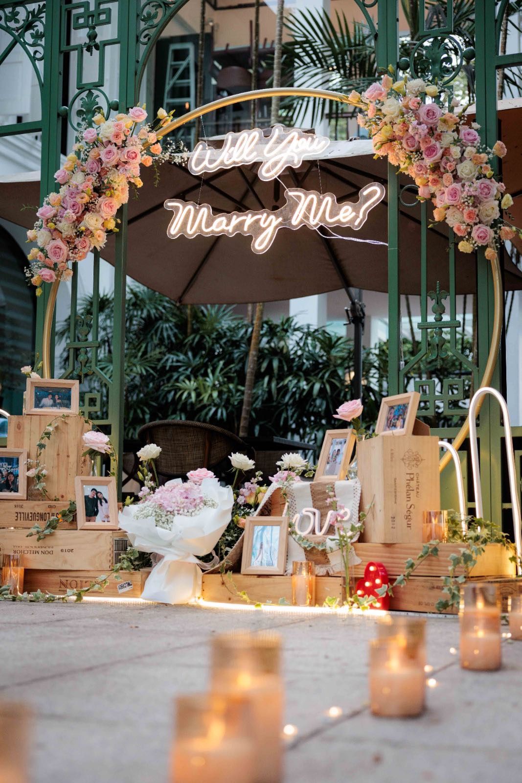 Floral arch with a Marry Me sign and candles