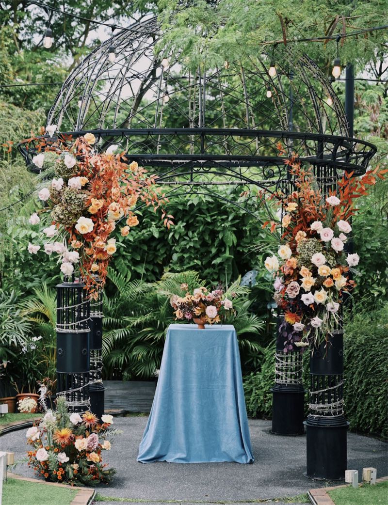 Peach and white floral arch in a garden