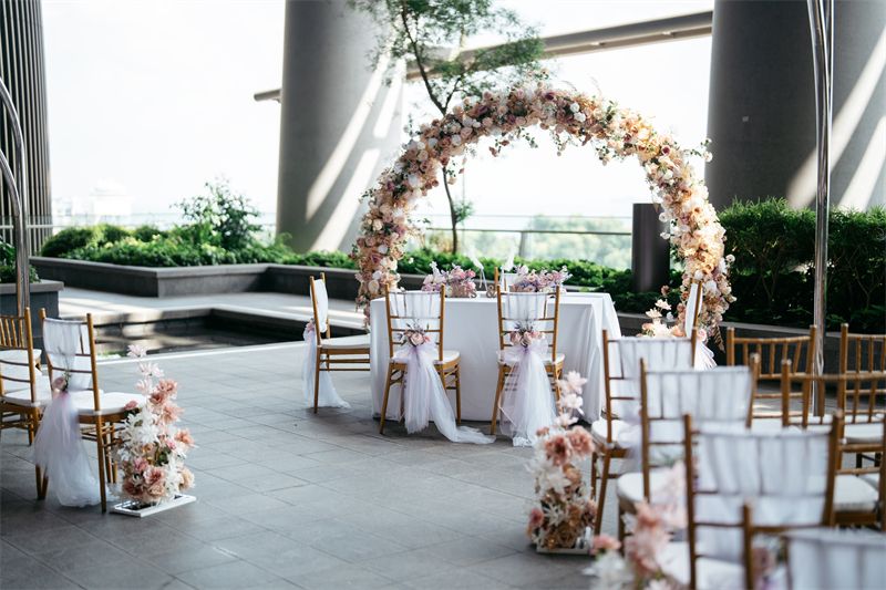 Floral arch and chairs set up for a rooftop wedding ceremony